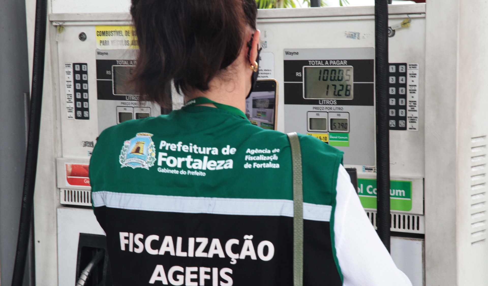 fiscal da agefis olha uma bomba de gasolina